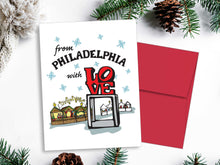 Christmas card with 'From Philadelphia with Love' text and red envelope on a white background with greenery.