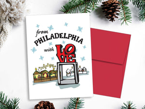 Christmas card with 'From Philadelphia with Love' text and red envelope on a white background with greenery.
