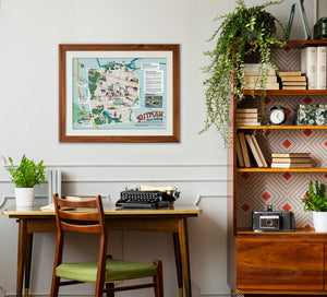 a framed copy of the illustrated Pitman map hangs above a small desk it a retro styled living area